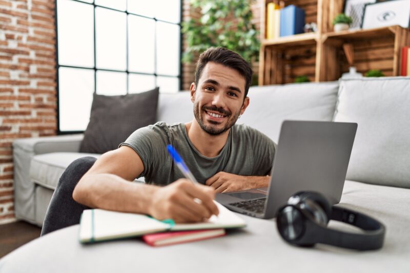 Young hispanic man smiling confident studying at home
